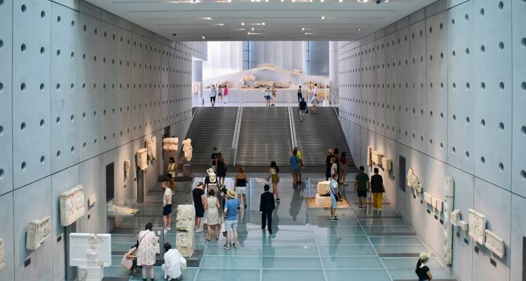 Visiteurs explorant un espace muséal d'architecture moderne.