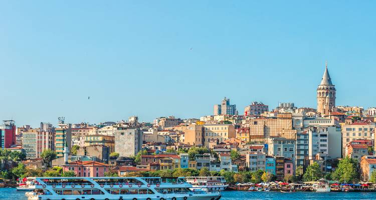 Skyline von Istanbul mit dem Galata-Turm im Blick und Wasserfahrzeugen auf dem Bosporus.