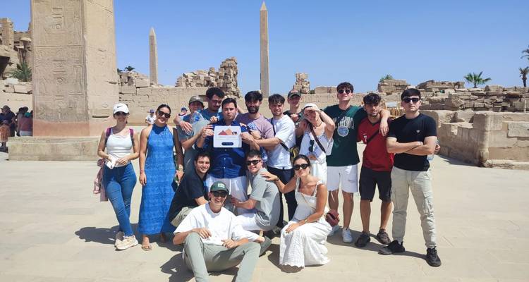 Groupe de touristes posant devant des ruines antiques.