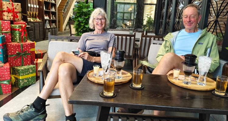 Deux personnes savourant des boissons dans un café en plein air.
