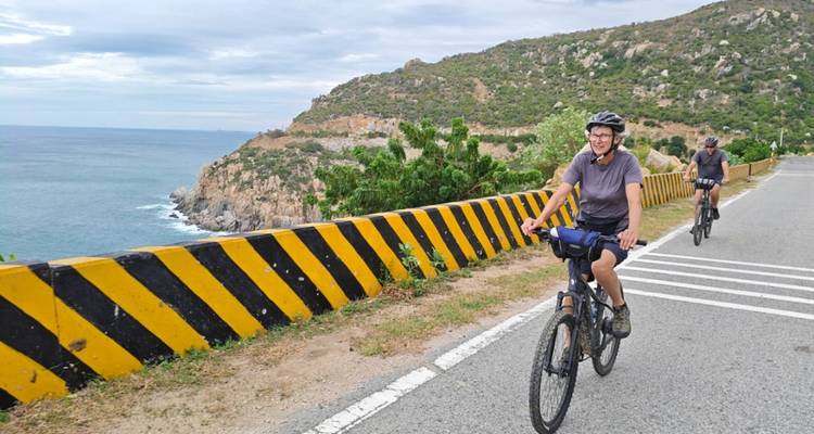 Cyclistes roulant le long d'une route côtière avec une vue panoramique.