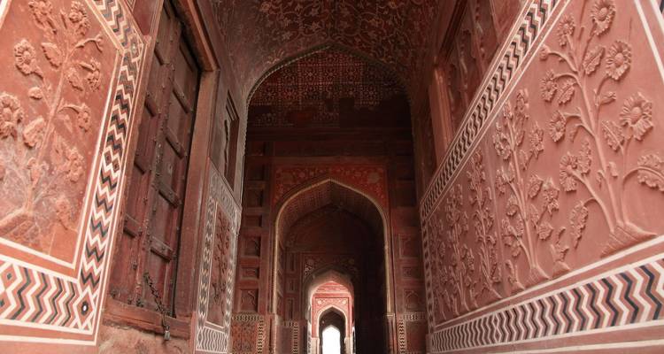 Arches complexes en grès rouge d'un monument historique.