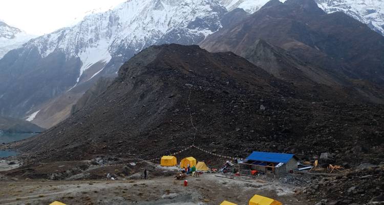 Campamento en un valle de montaña con carpas coloridas.