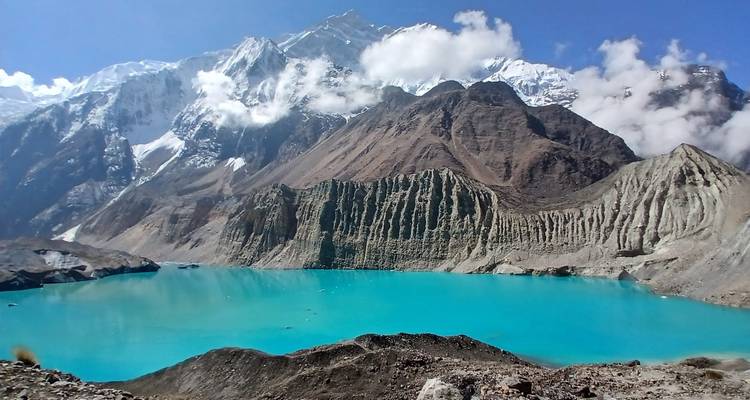 Lago glacial turquesa con montañas bajo un cielo azul.