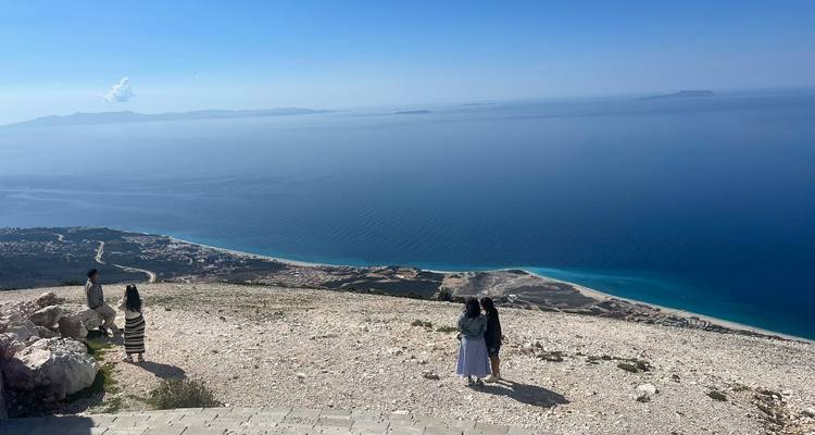 Point de vue panoramique en hauteur au-dessus de la mer Ionienne avec des visiteurs admirant le vaste horizon bleu.