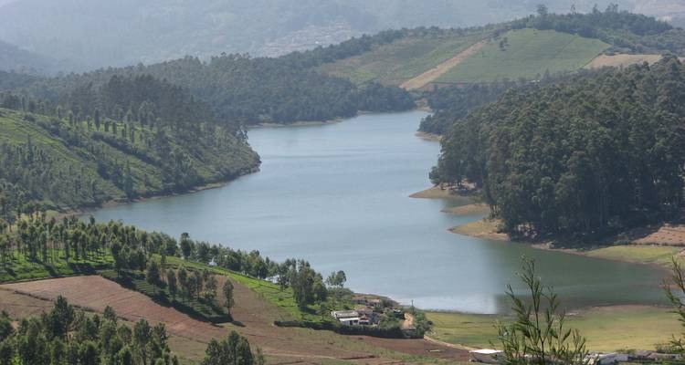 Schilderachtig uitzicht op een meer omringd door weelderig groene heuvels.