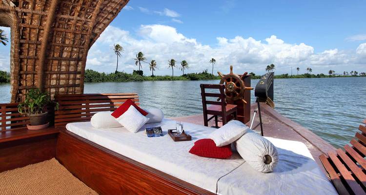 Luxe woonboot op een meer met palmbomen.