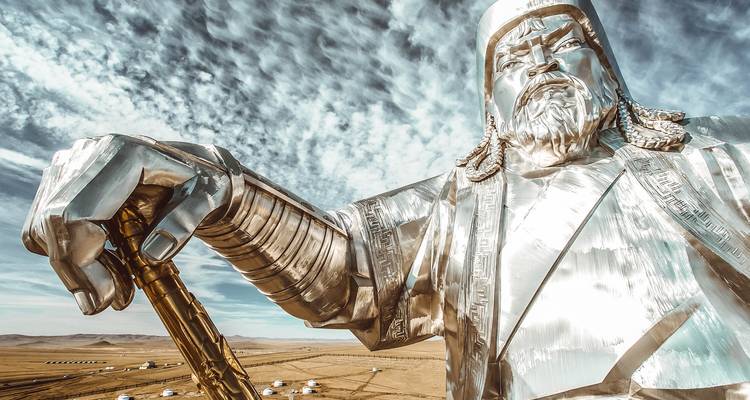 Une gigantesque statue étincelante en acier inoxydable de Gengis Khan se dresse contre des nuages striés au-dessus de la steppe mongole.
