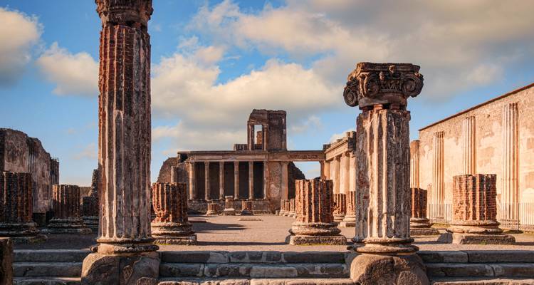 Colonnes de pierre et ruines de temple de Pompéi se dressant contre un ciel lumineux.