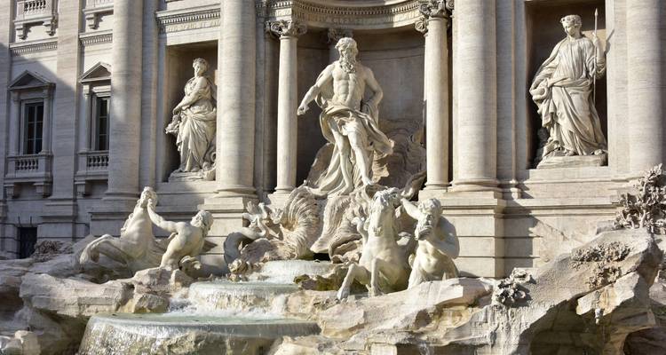 Sculptures de marbre détaillées de la fontaine de Trevi avec une eau claire qui coule.