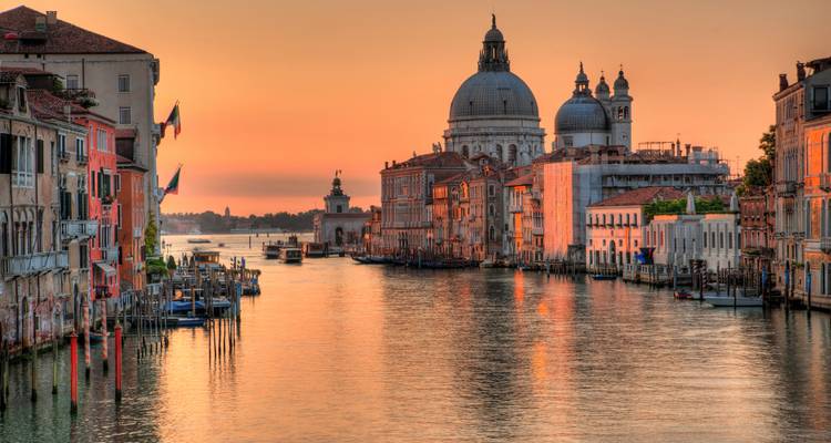 Lever de soleil serein sur le Grand Canal de Venise avec Santa Maria della Salute et reflets pastel sur l'eau.
