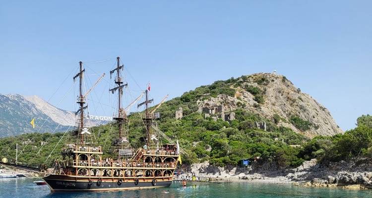 Piratenschip dat vaart nabij een rotsachtige heuvel met ruïnes.