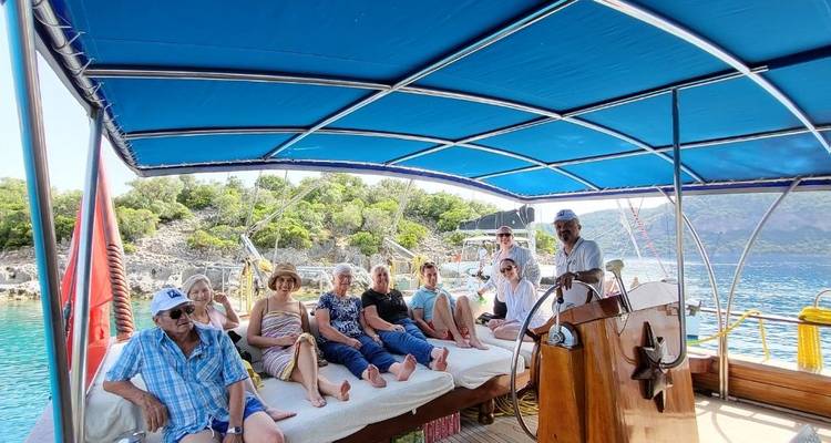 Groep mensen die ontspannen op een boot met schilderachtig uitzicht op de kust.
