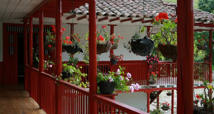 Traditional style house with red railings and flower pots.