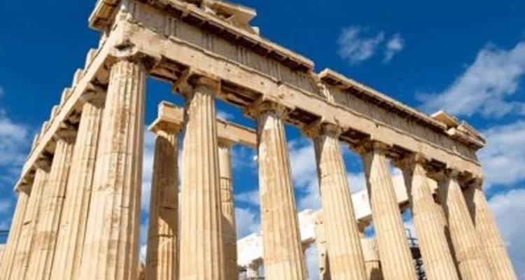Templo griego antiguo con columnas bajo un cielo azul.