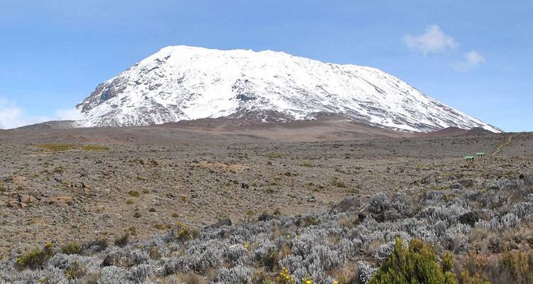 Le mont Kilimandjaro avec son sommet enneigé et son vaste paysage rocheux.