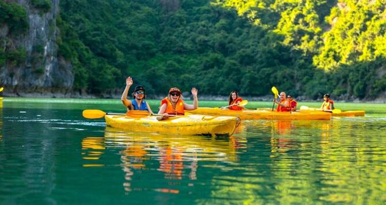 Des gens faisant du kayak sur un plan d'eau serein entouré de collines verdoyantes.