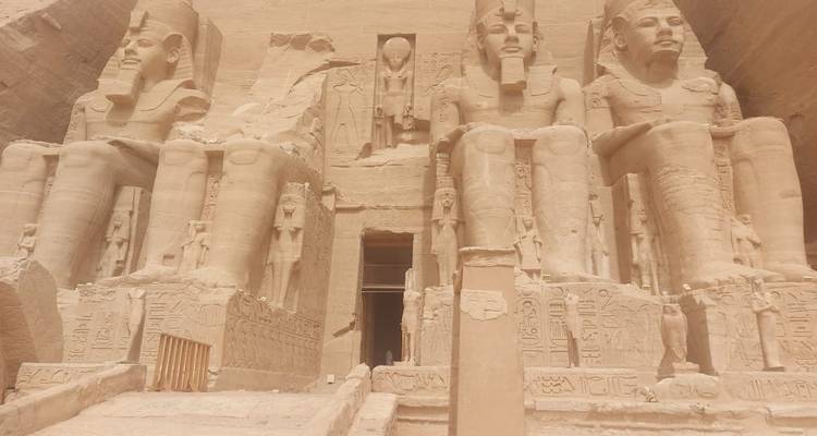 Colossal statues of pharaohs at the entrance of a temple.