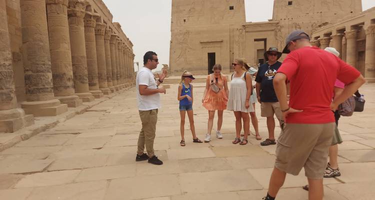 Tour group exploring ancient ruins with a guide.