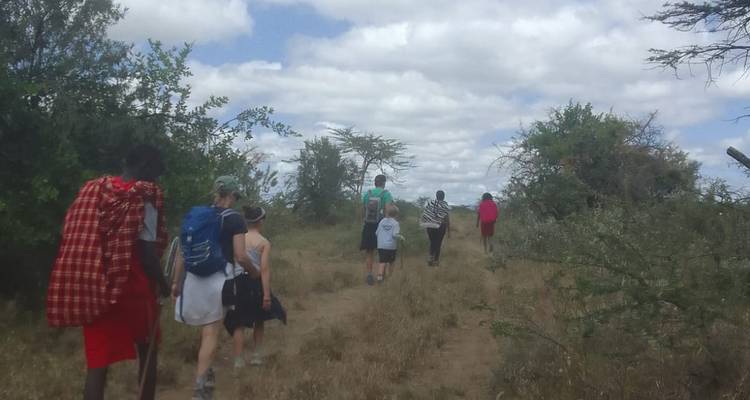 Groupe de personnes faisant de la randonnée sur un sentier à travers un paysage aride.