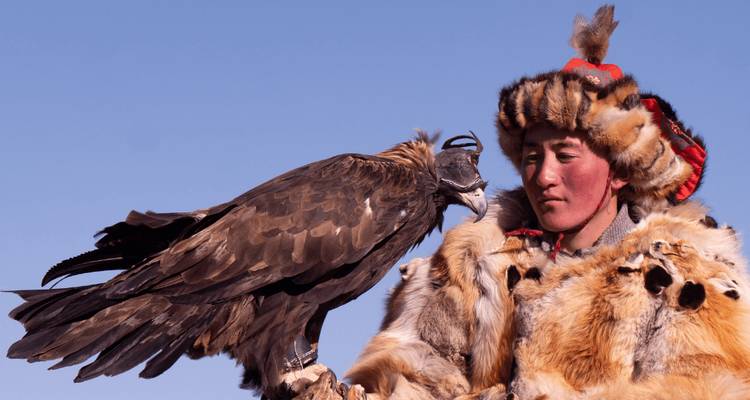 Cazador de águilas en atuendo tradicional con águila.