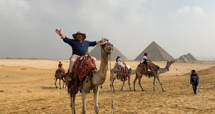 People riding camels in front of the Pyramids