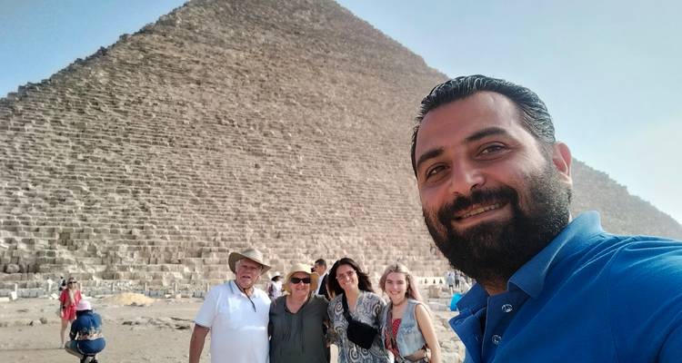 People taking a selfie with the Great Pyramid of Giza in the background.