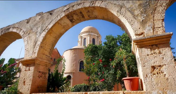 Arche menant à une structure en forme de dôme entourée de verdure.