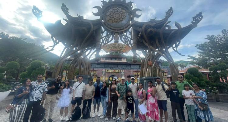 Groupe devant une grande entrée d'un parc d'attractions.