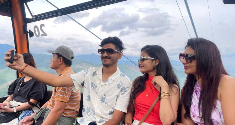 Des personnes prenant un selfie dans un téléphérique surplombant des vues panoramiques.