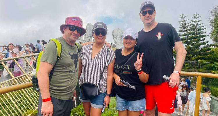 Groupe de touristes posant sur une plateforme bondée avec des vues brumeuses.