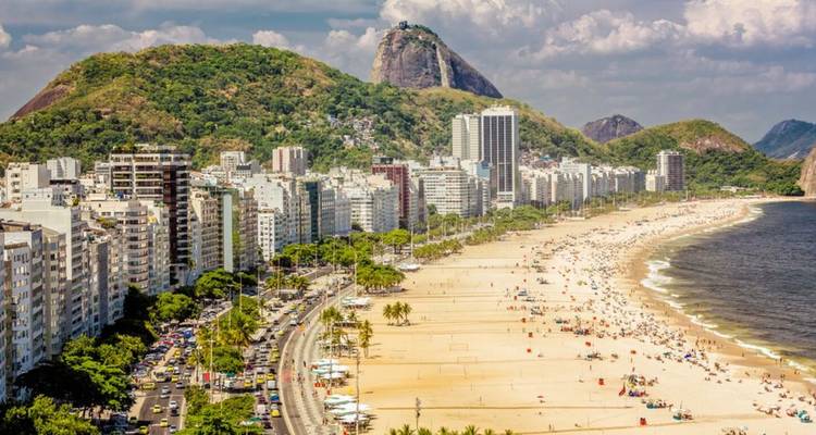 Het iconische Copacabana-strand dat zich uitstrekt langs de wolkenkrabbers met de Sugarloaf Mountain op de achtergrond.