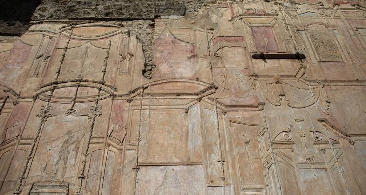 Ancient frescoes on a wall in Pompeii.