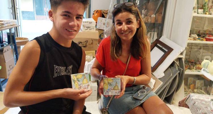 Two people holding colorful ceramic items.