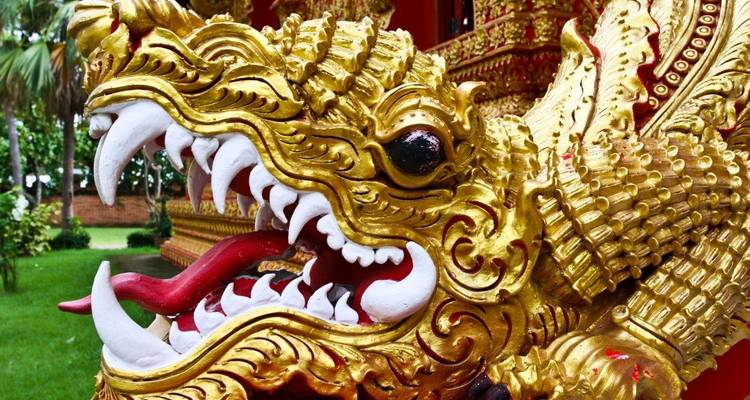 Gros plan d'une statue de dragon doré ornementée.