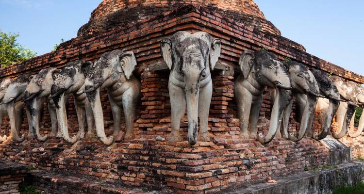 Sculptures d'éléphants autour des vestiges d'un temple ancien.