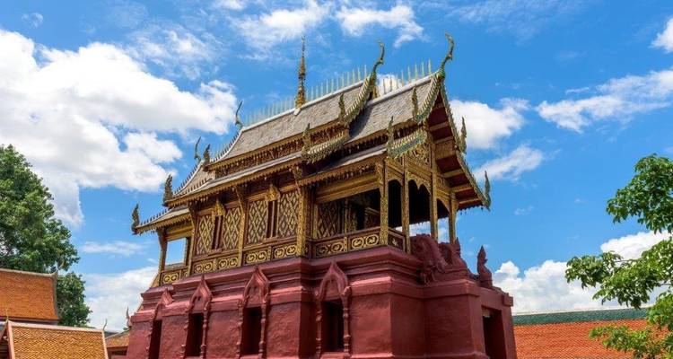 Bâtiment de temple orné avec des détails dorés et un ciel dégagé.