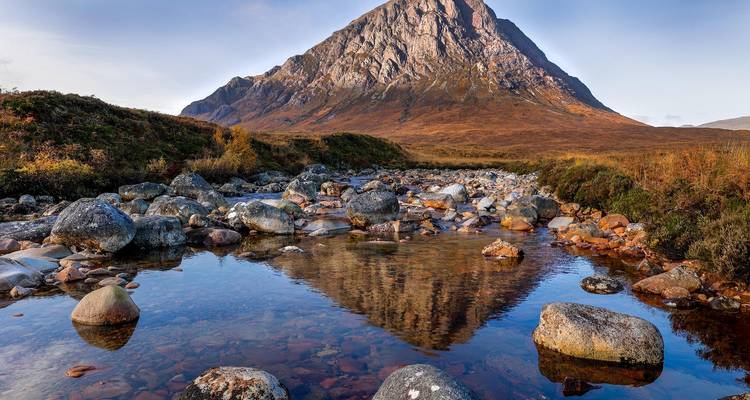 Gran montaña con un arroyo que la refleja en primer plano.