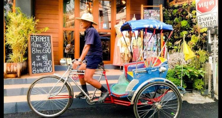 Homme en chapeau traditionnel conduisant un taxi-tricycle.