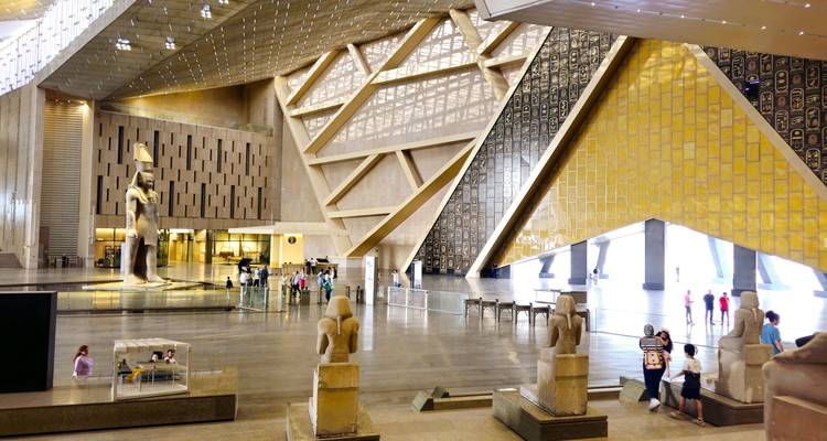 Grand intérieur d'un musée avec des statues et des personnes.