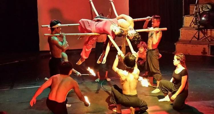 Artistas demostrando un acto de tragafuegos en el escenario.