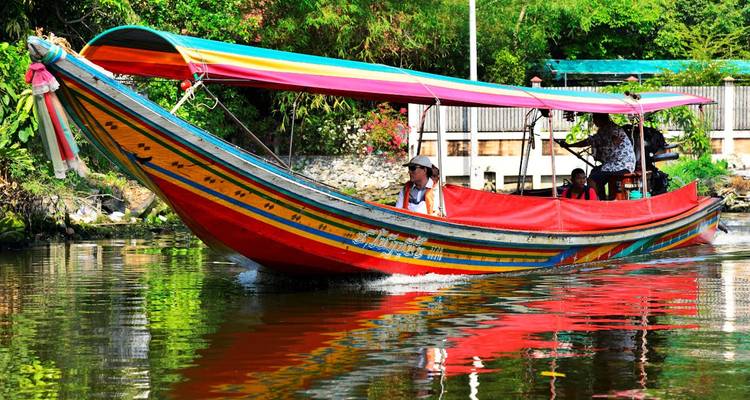 Buntes Boot auf einem Fluss mit Menschen an Bord.