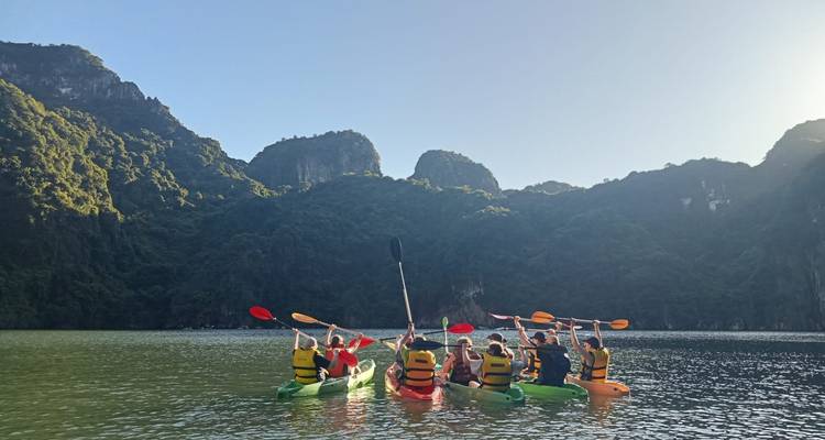 Gruppe von Menschen beim Kajakfahren in einer malerischen Bucht.