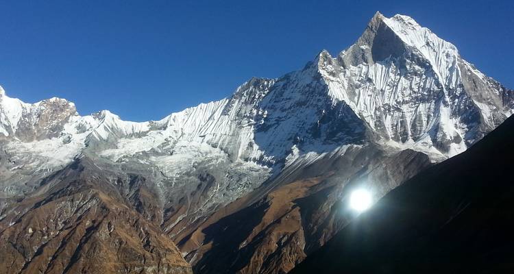 Mountain range covered with snow under a clear blue sky.