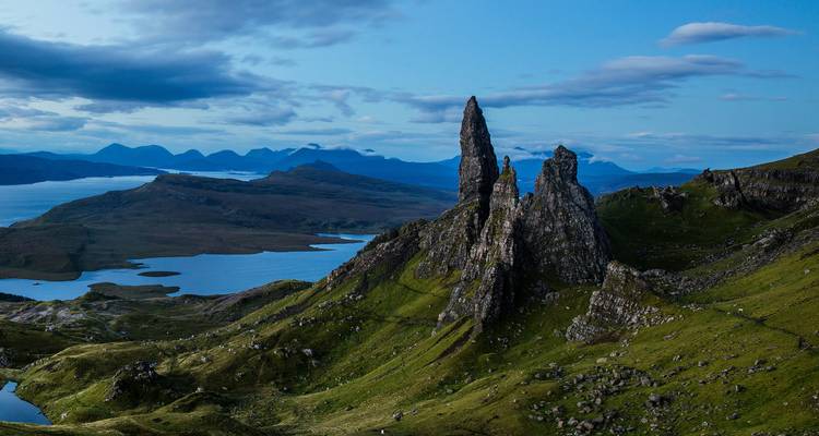 Formations rocheuses majestueuses et montagnes sous un ciel bleu.