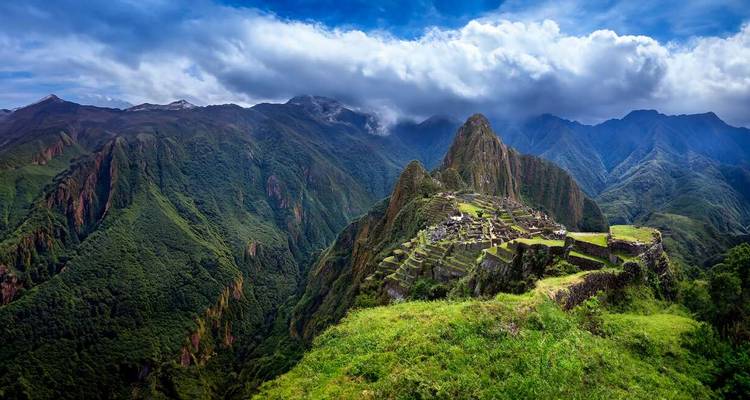 Vue panoramique du Machu Picchu avec un arrière-plan montagneux spectaculaire.