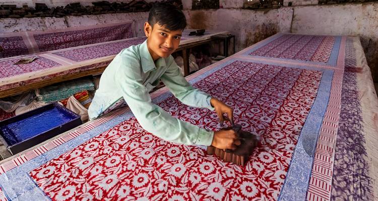 Personne imprimant du tissu avec un tampon en bois.