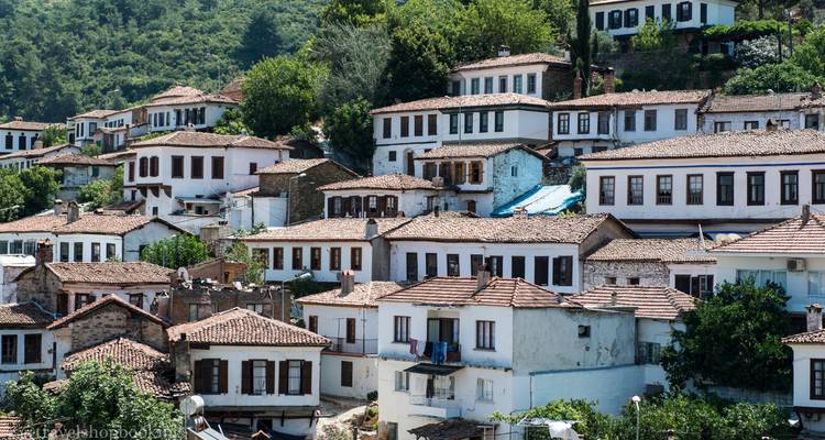 Terrassierte Häuser aus der osmanischen Zeit in einem malerischen Hügeldorf, umgeben von Wald.