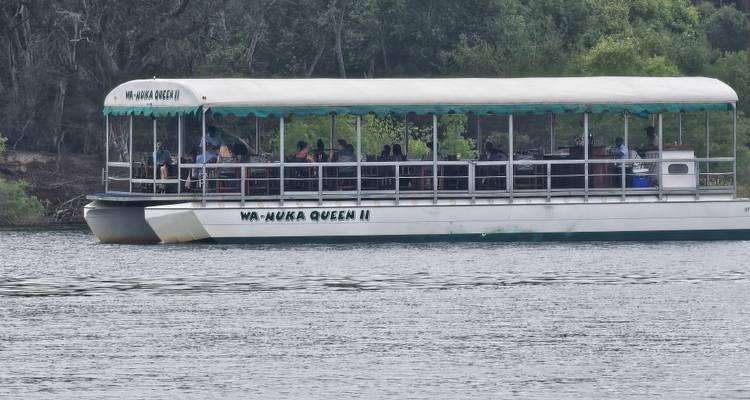 Un bateau fluvial nommé Ma-Ruka Queen II avec un groupe de personnes naviguant sur une rivière.