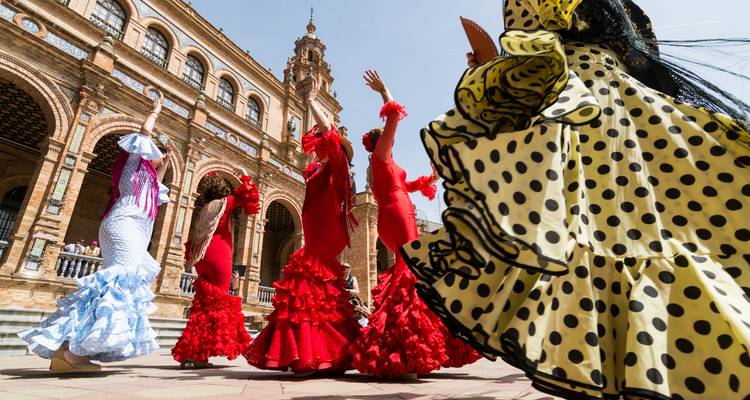 Danseurs de flamenco en tenue traditionnelle se produisant devant un bâtiment historique.